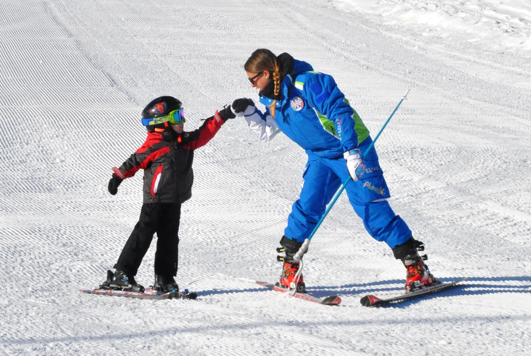 Lezione di sci con una maestra e un bambino sulle piste