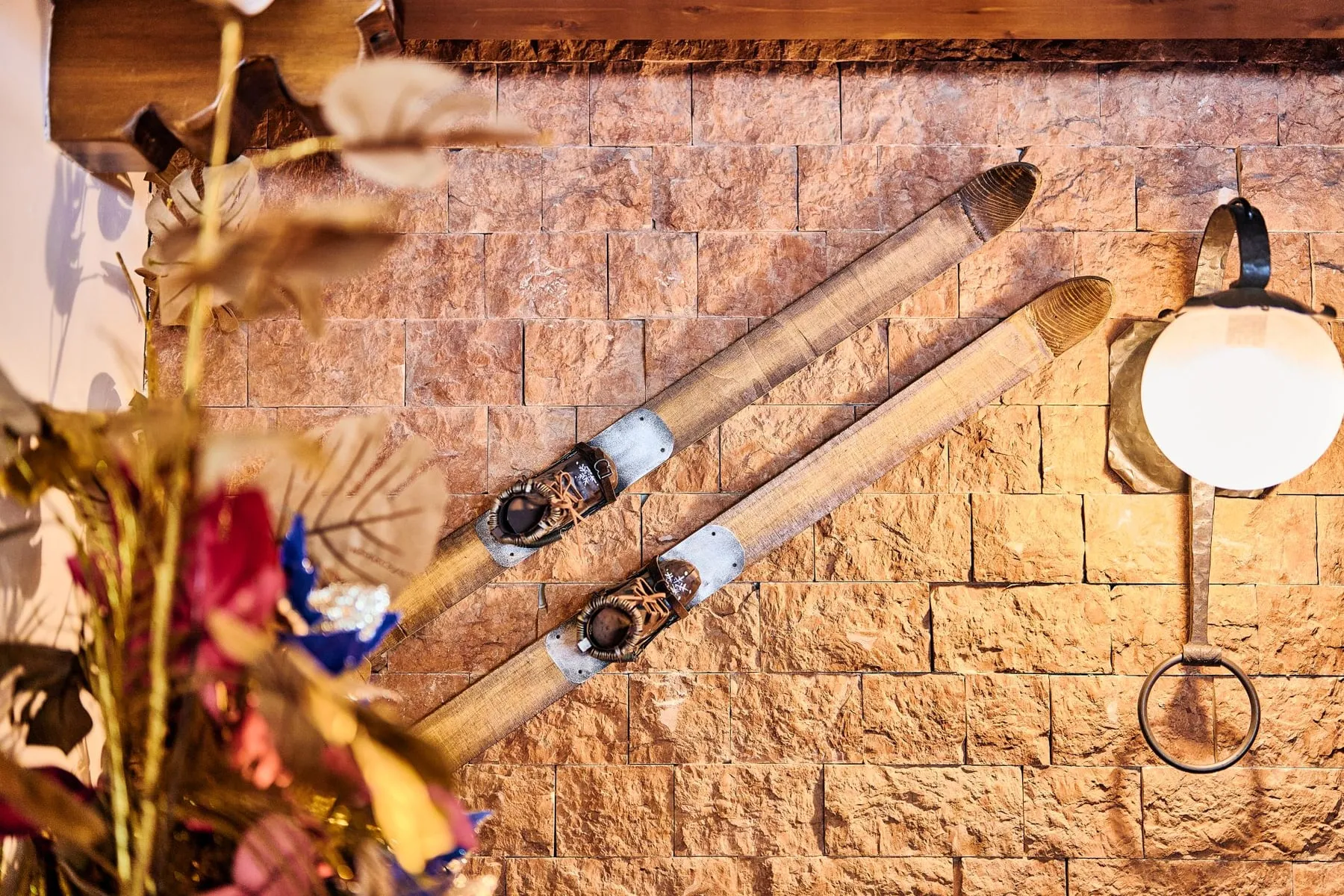 Wooden skis on a stone wall at Hotel Pizzalto